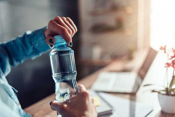 Botol air di tas dan meja kerja